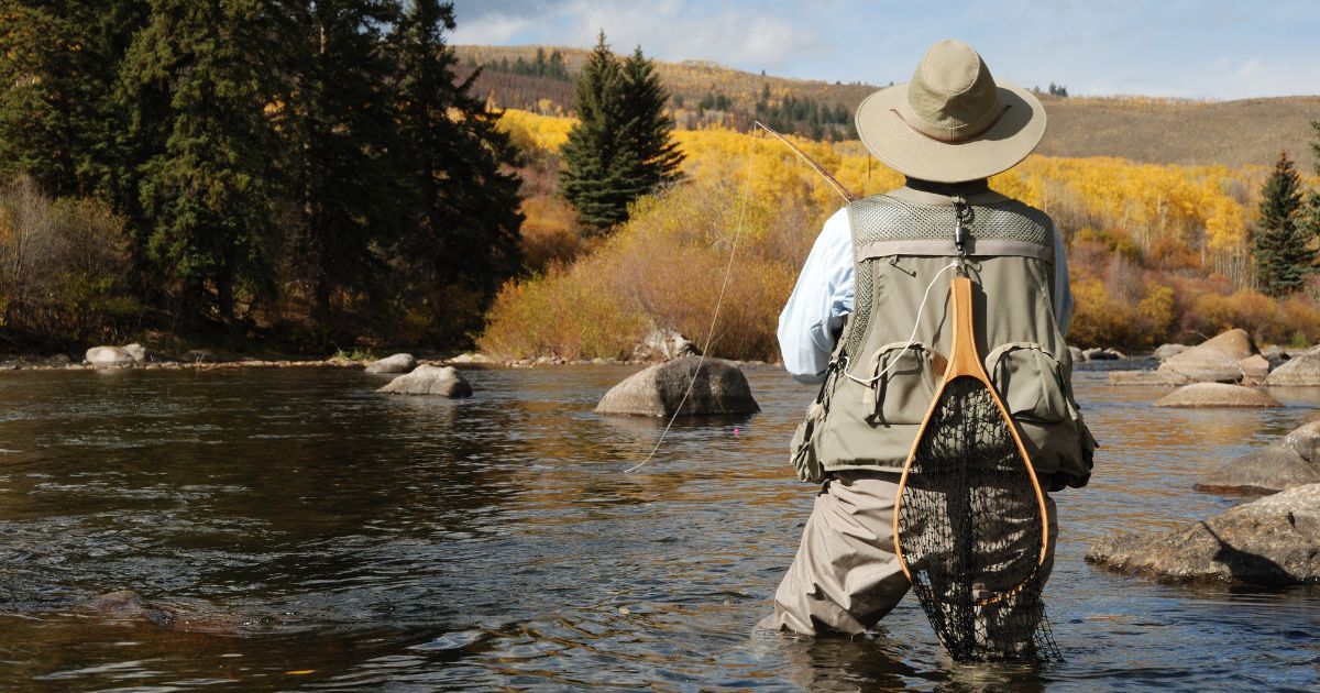 person flyfishing in river