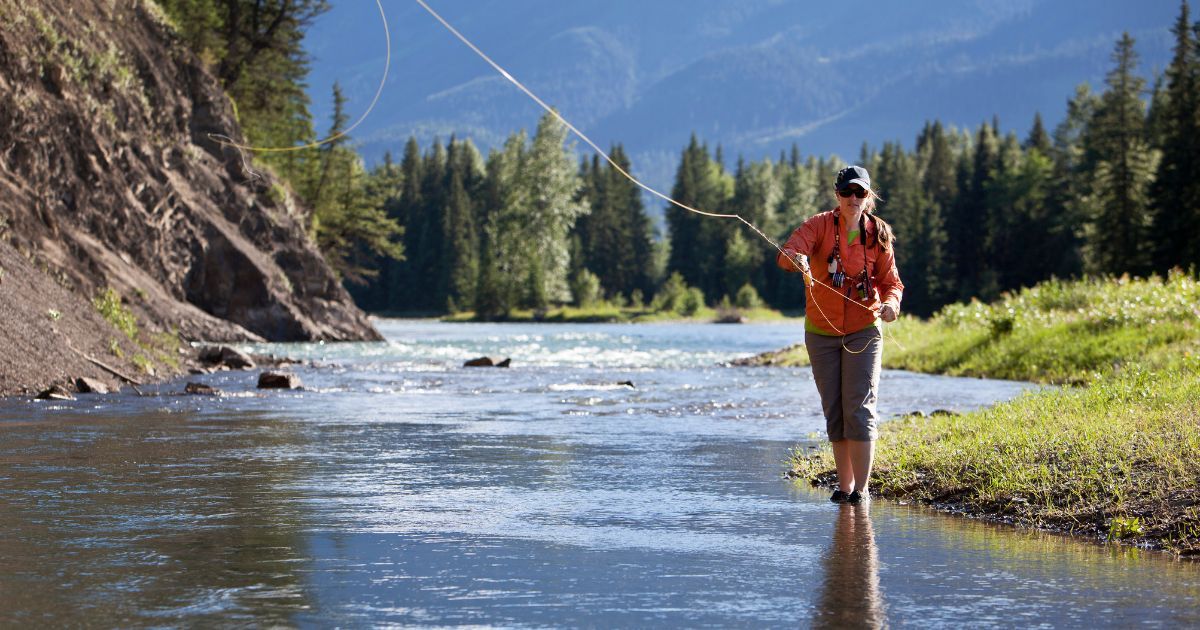 woman flyfishing in stream