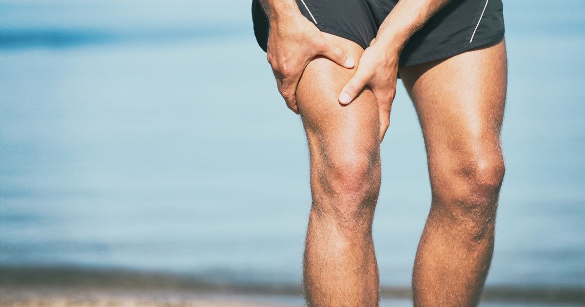 man holding his quad in pain