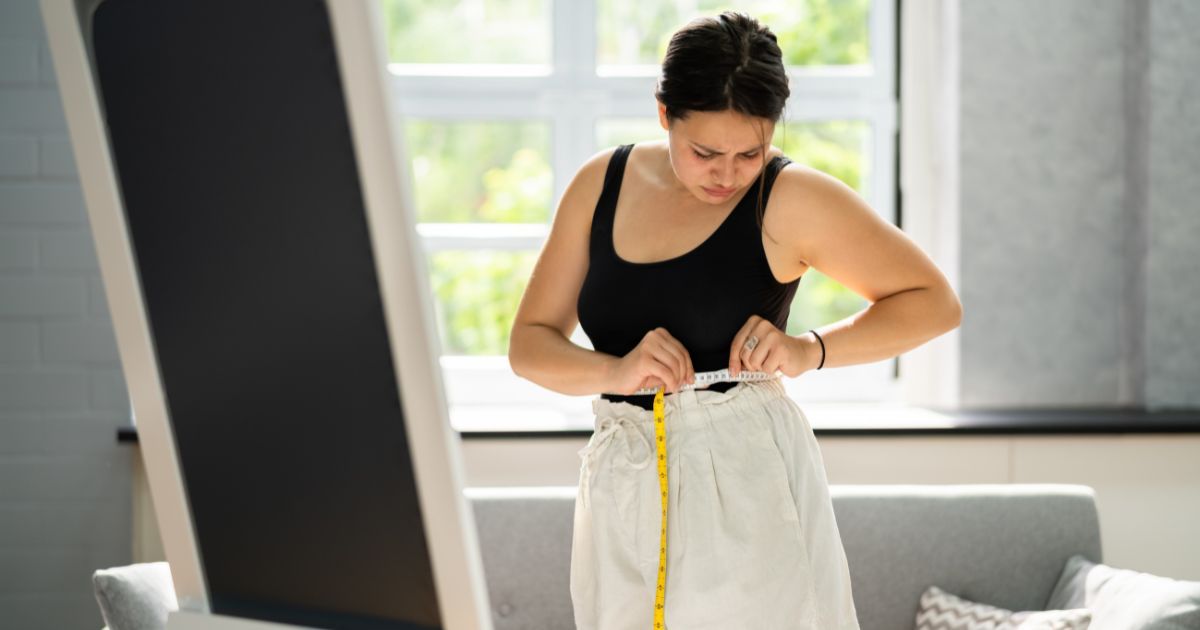 Woman measuring waist size
