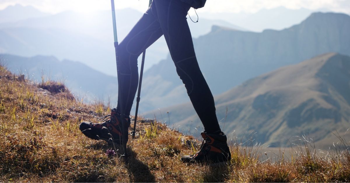 person hiking with trekking poles