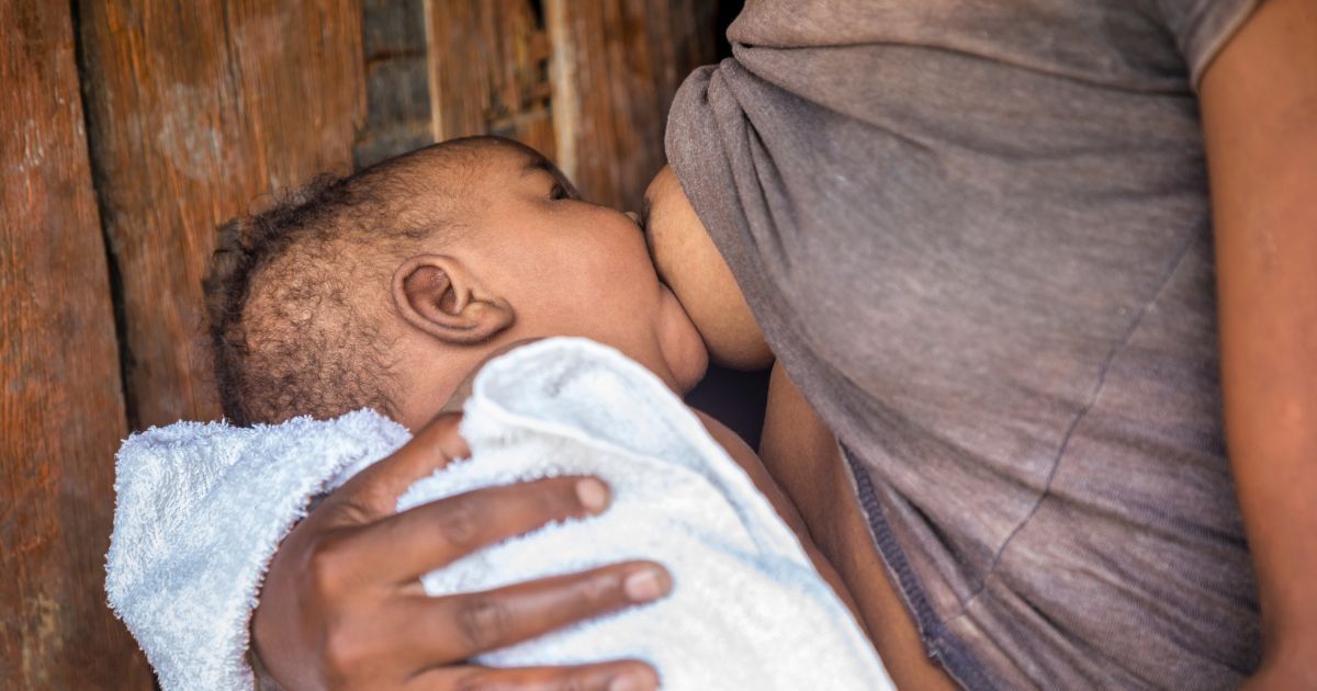 african woman breastfeeding her baby outdoors