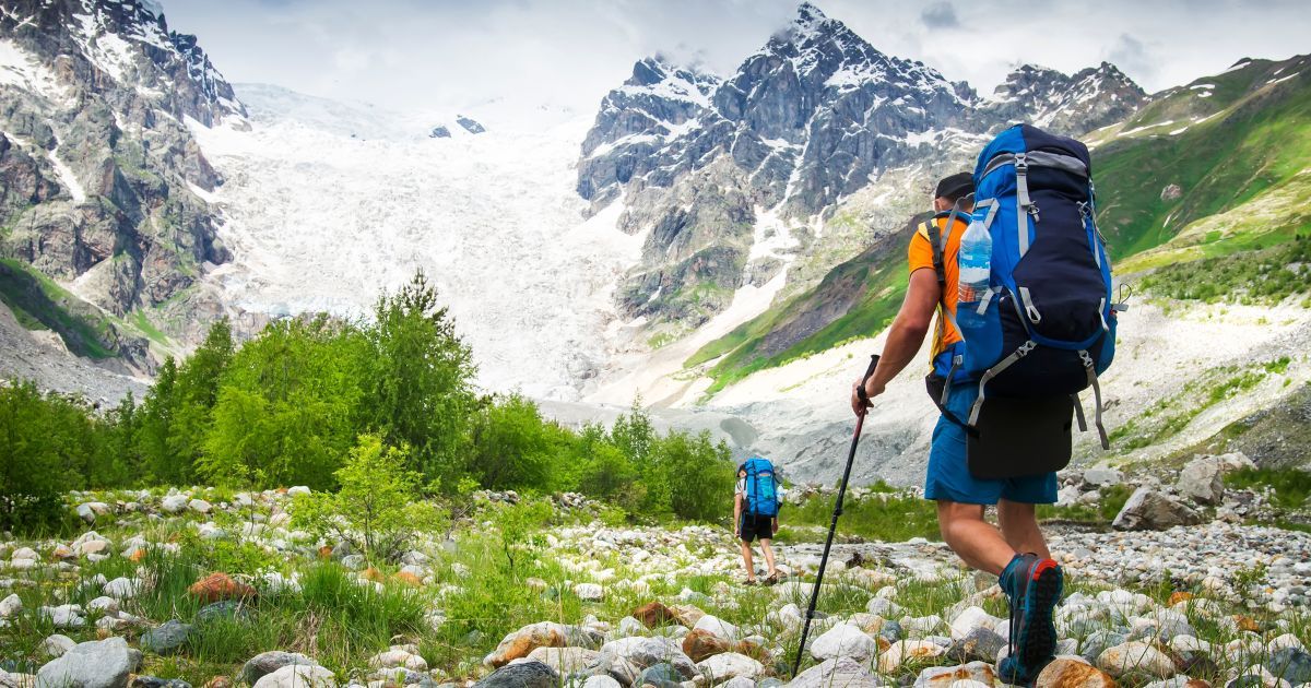 backpackers hiking towards mountains