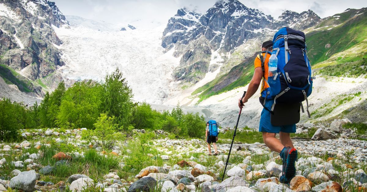 two backpackers hiking towards mountains