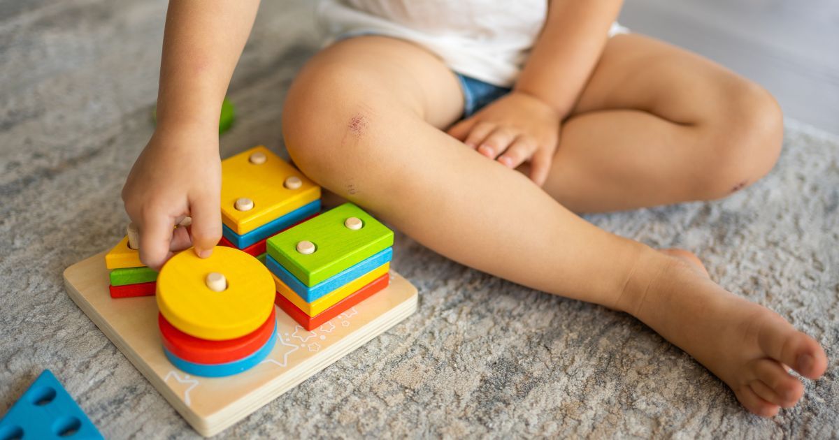 child playing with wood stacking toy