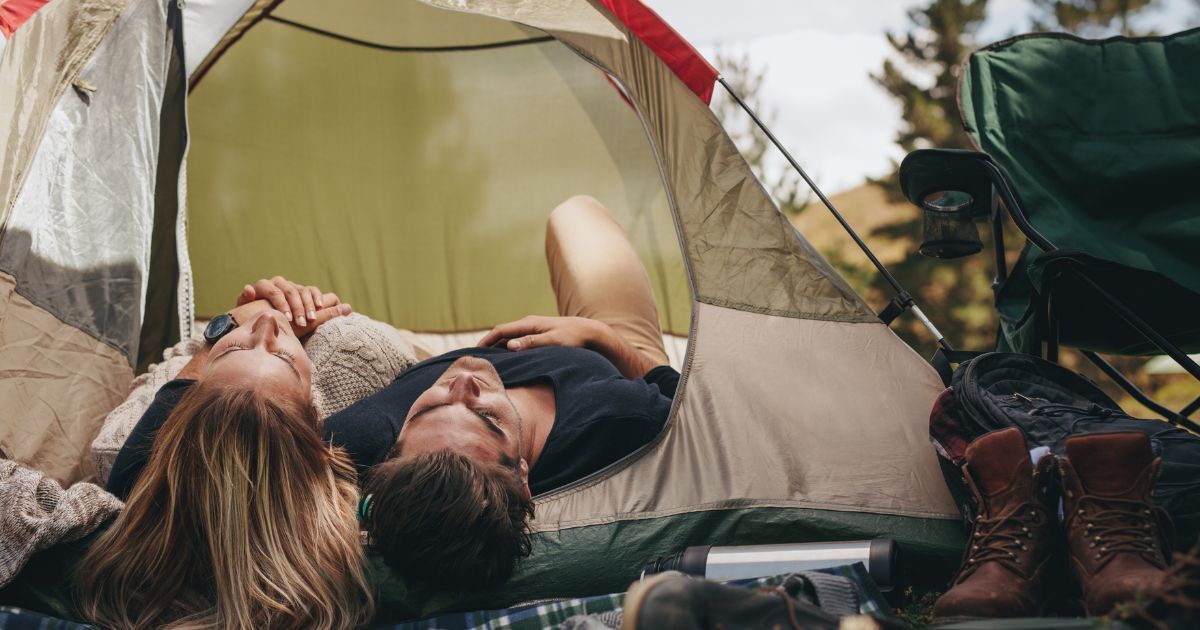man and woman lying down in tent