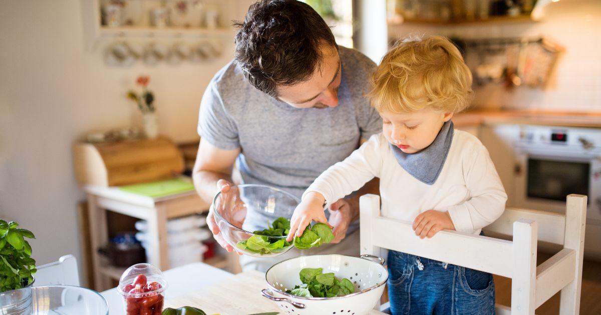 father and toddler cooking together