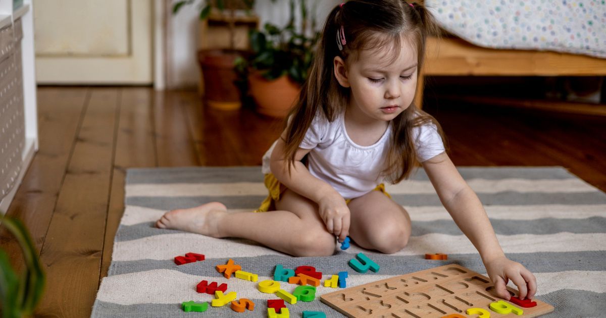 girl playing with alphabet letters