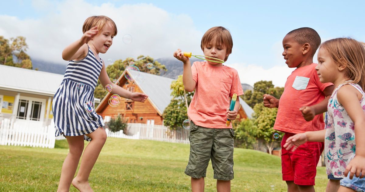 kids outside a Montessori school playing with bubbles