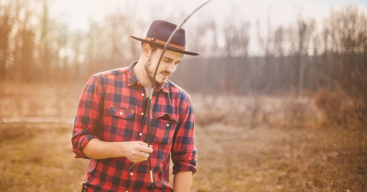 man installing tent poles at campsite