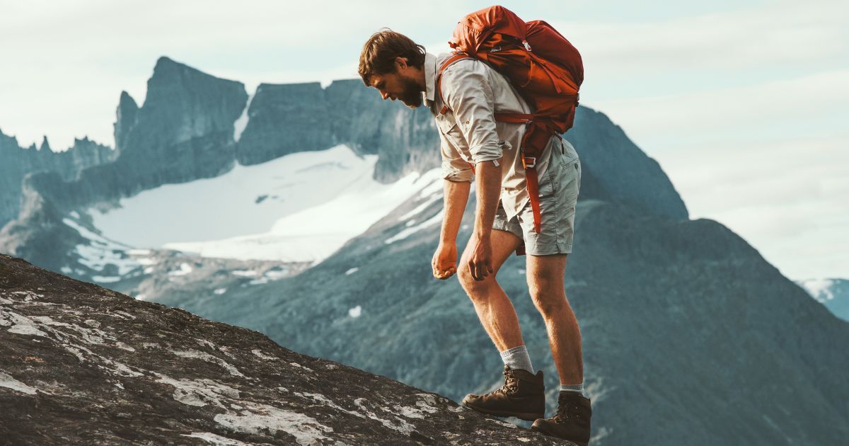 tired man hiking with a backpack in the mountains