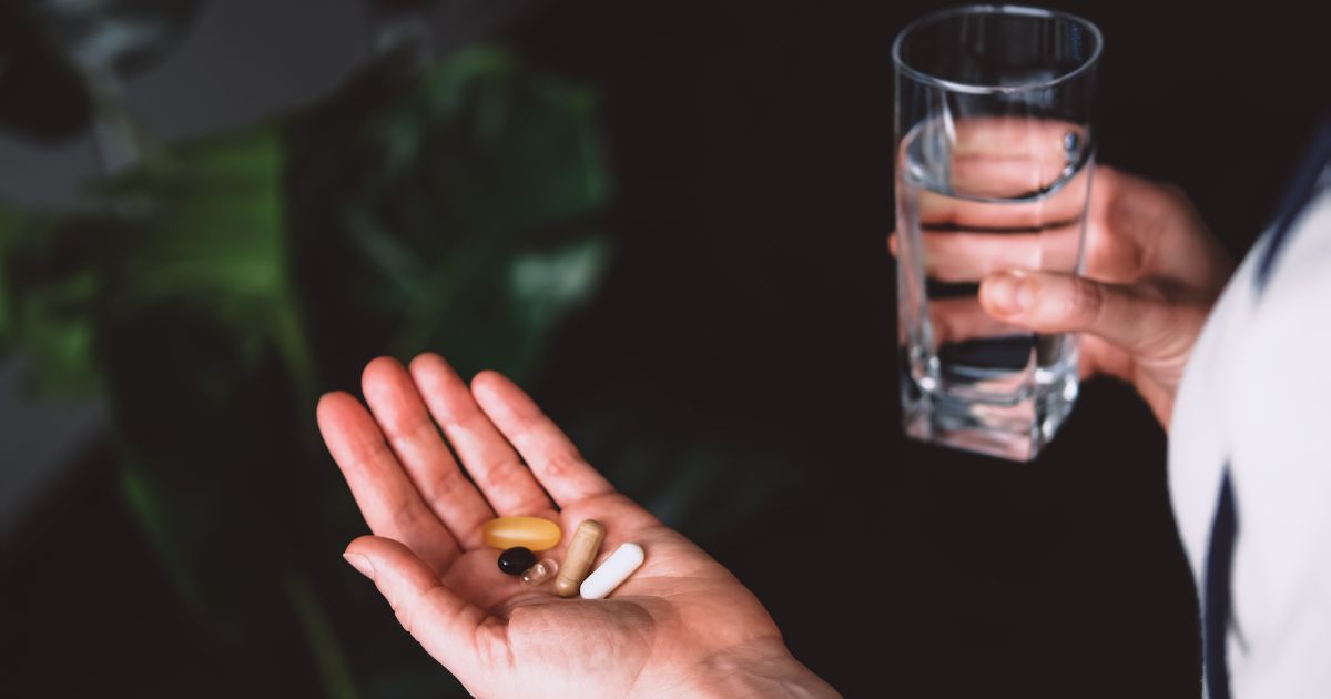 woman holding vaious supplements in her hand
