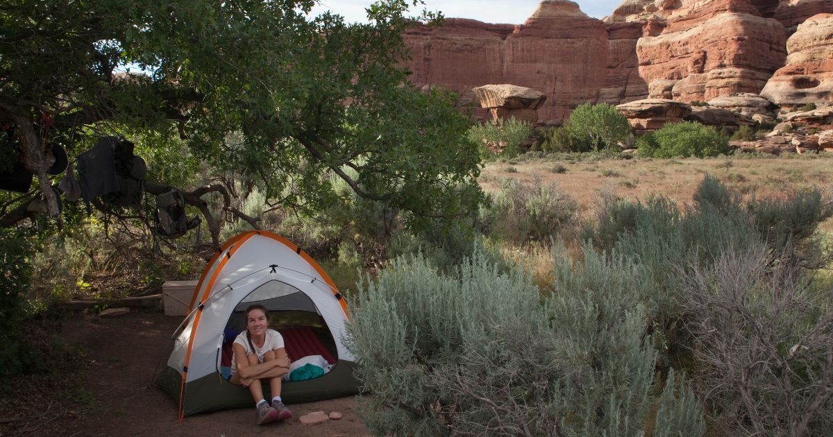 small lightweight backpacking tent setup with woman sitting inside