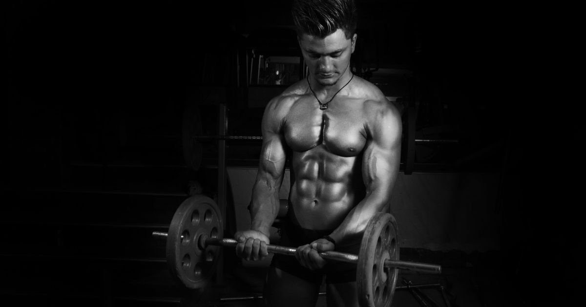 muscular man curling a barbell