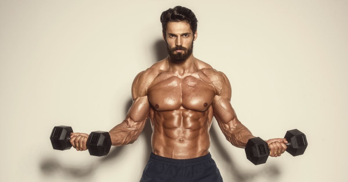 muscular male with dumbells in hands