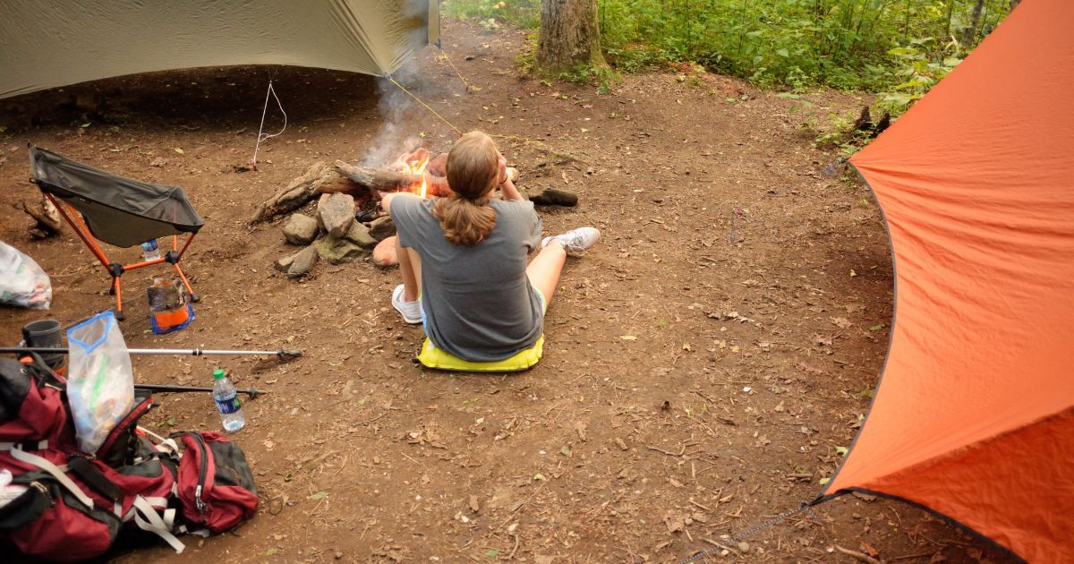 girl relaxing by tarp tents