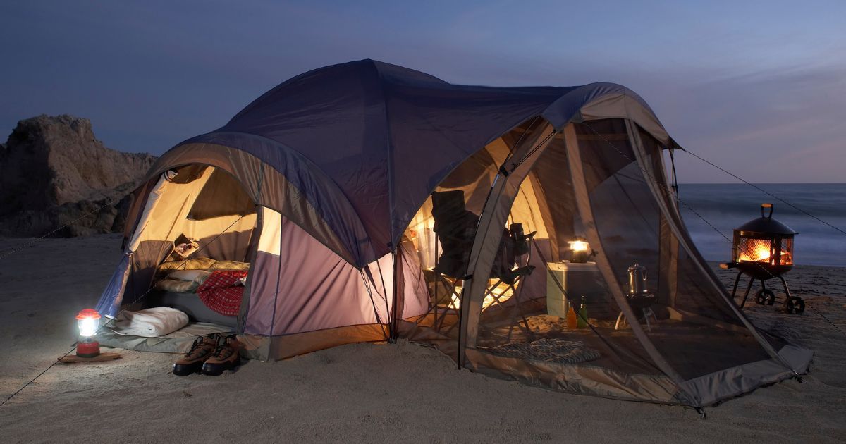 large tent with screen room setup on a beach