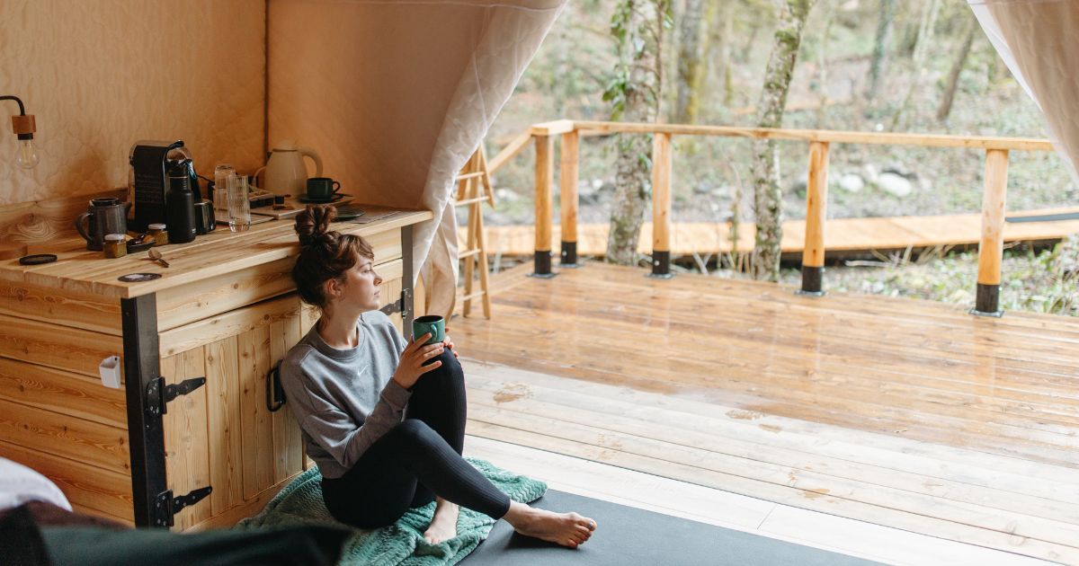 woman sitting comfortably in tent with coffee