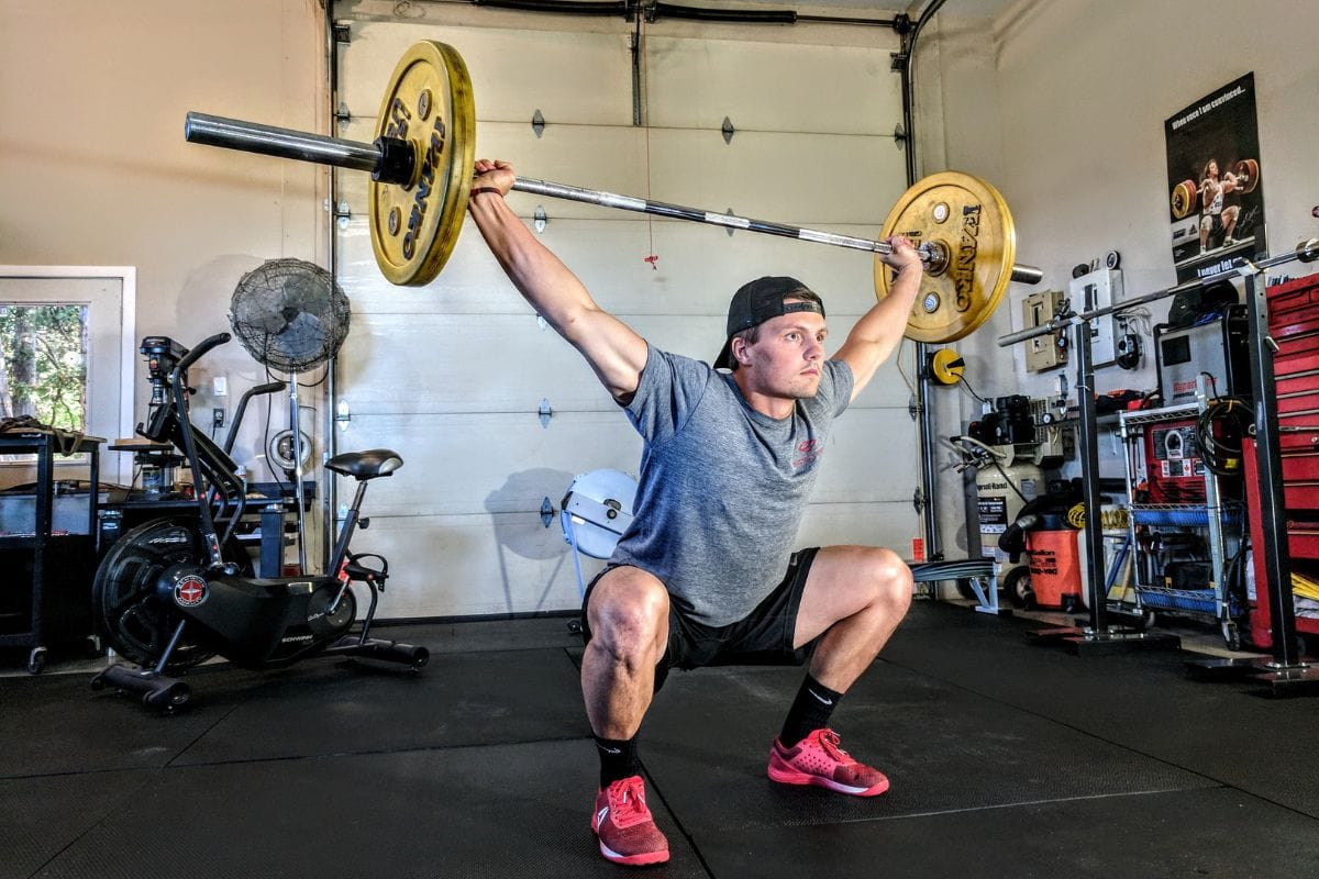man snatching weight overhead