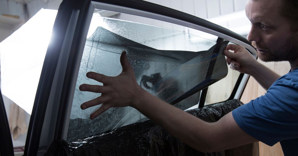 man installing window tint